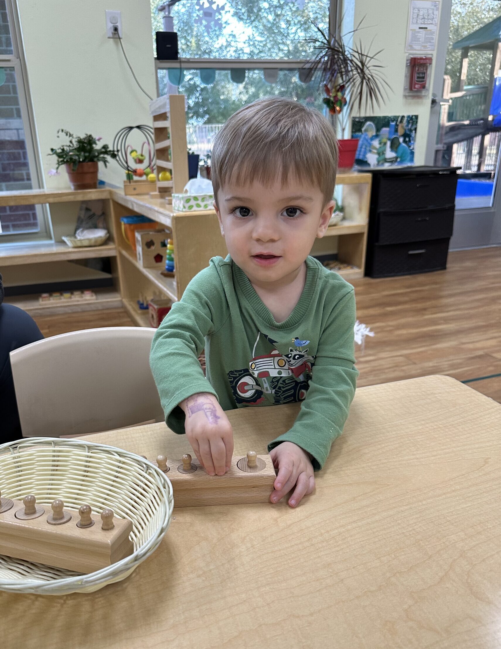 Toddler practicing sensorial activity in Montessori classroom as part of our toddler Montessori programs in Richmond, TX
